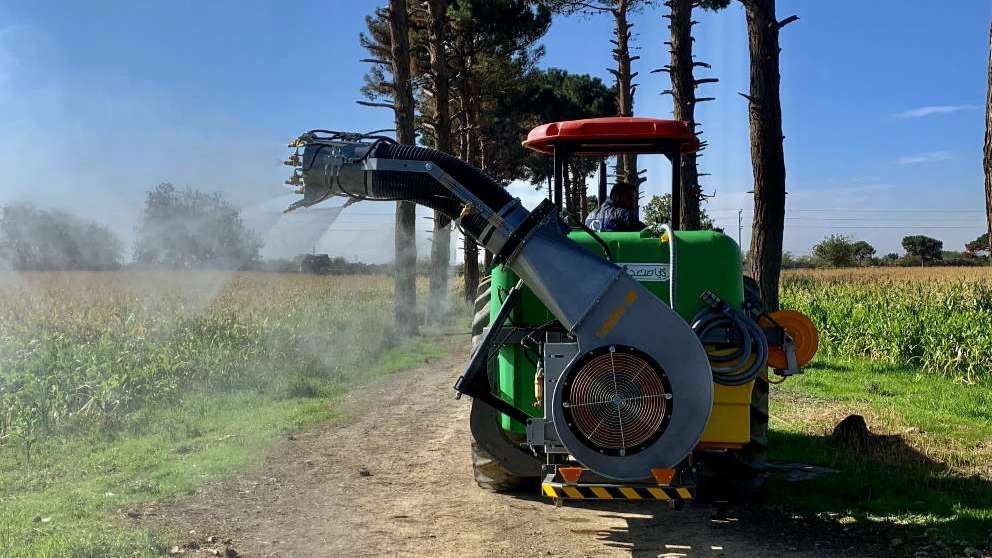 The sprayer behind the riding tractor